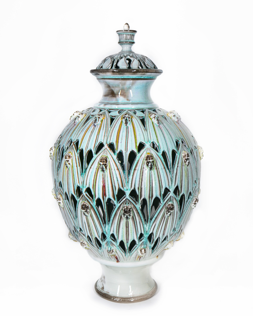 Pale celadon jar with deeply pierced petal lattice and faces