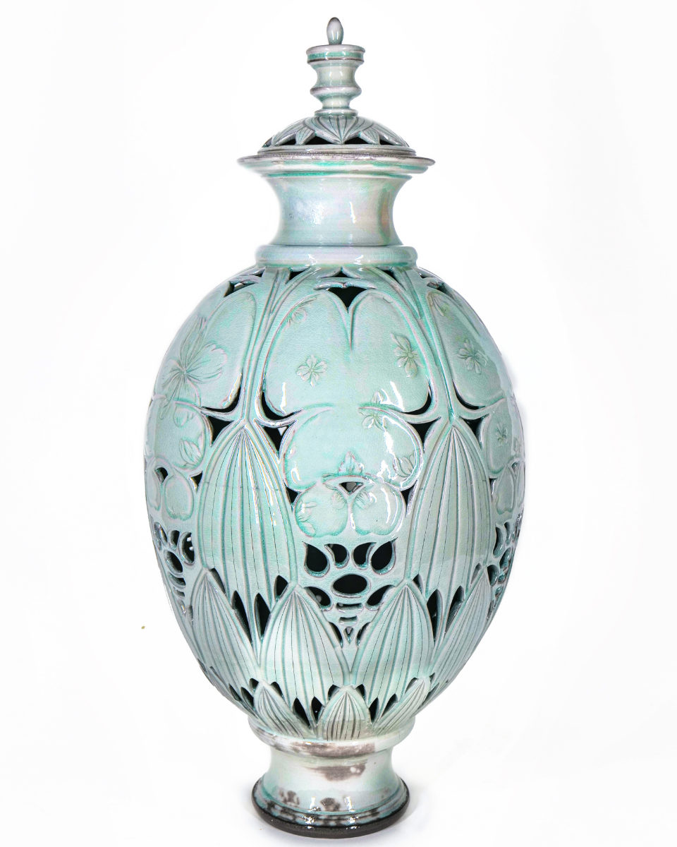 Mint celadon lidded jar with pierced floral carving