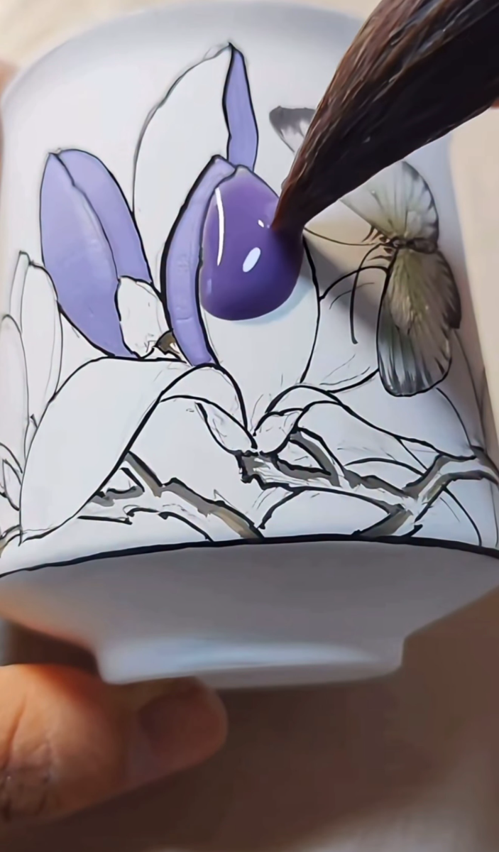 Violet petals painted onto a cup, with a butterfly motif alongside