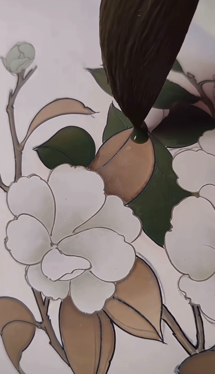A finished panel of white blossoms with green and tan leaves