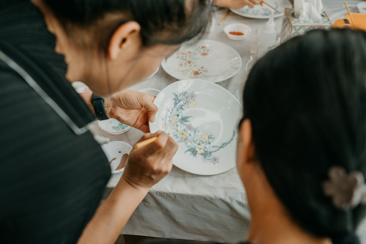 Yunting Li guiding a student at the painting table